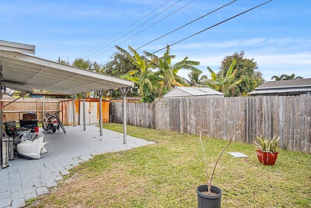 view of yard with a storage shed and a patio area