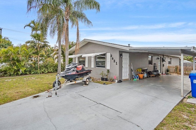 view of front of property with a carport and a front lawn