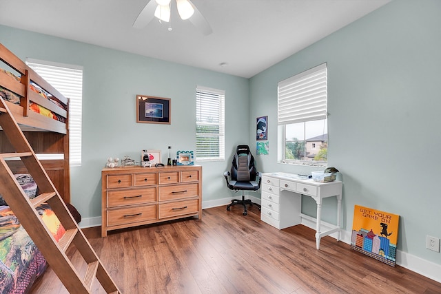 home office with hardwood / wood-style flooring and ceiling fan