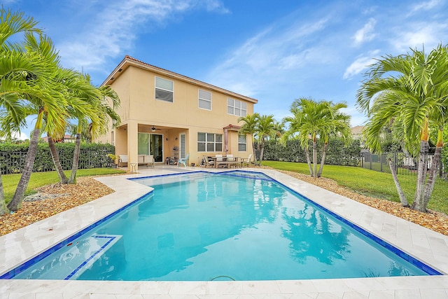 view of swimming pool featuring ceiling fan, a patio area, and a lawn