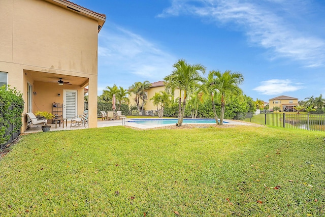 view of yard with a fenced in pool, a patio, a water view, and ceiling fan