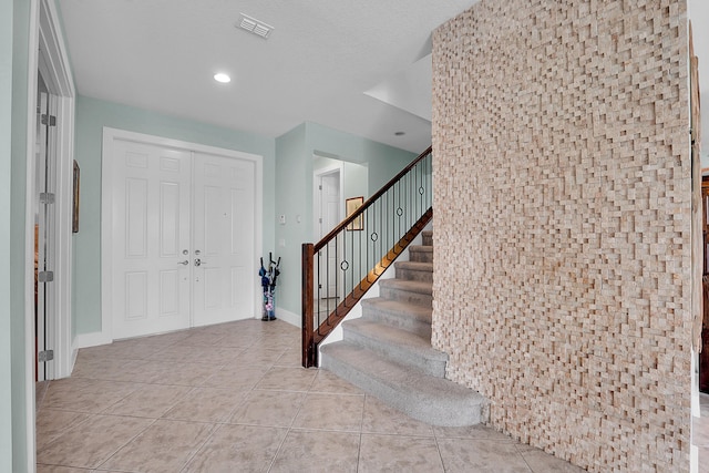 tiled foyer entrance featuring a textured ceiling