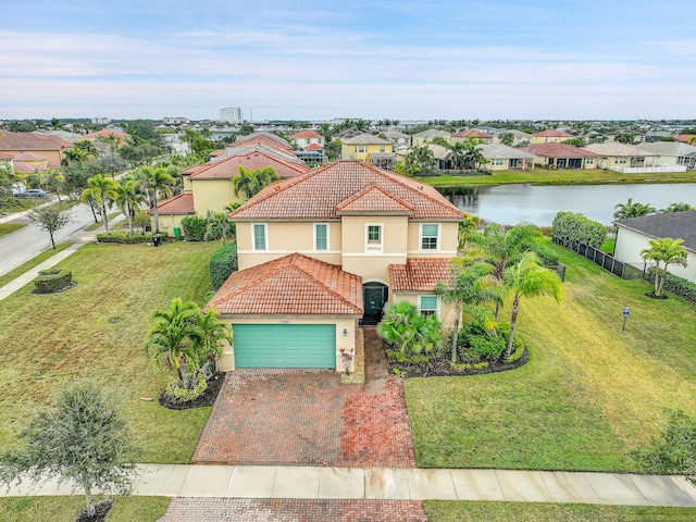 mediterranean / spanish-style home featuring a garage, a water view, and a front lawn