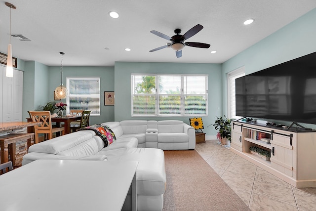 tiled living room with a textured ceiling and ceiling fan