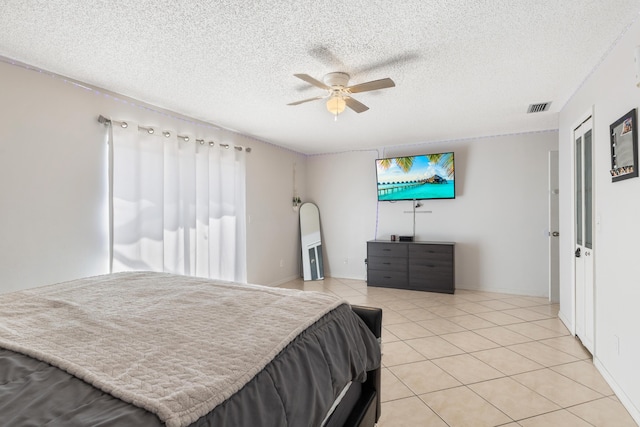 bedroom with ceiling fan, a textured ceiling, and light tile patterned floors