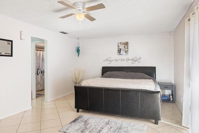 tiled bedroom featuring ceiling fan and a textured ceiling