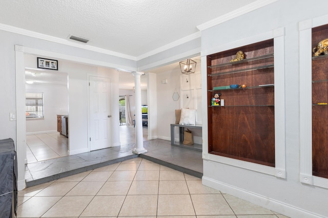 interior space featuring ornate columns, crown molding, baseboards, and visible vents