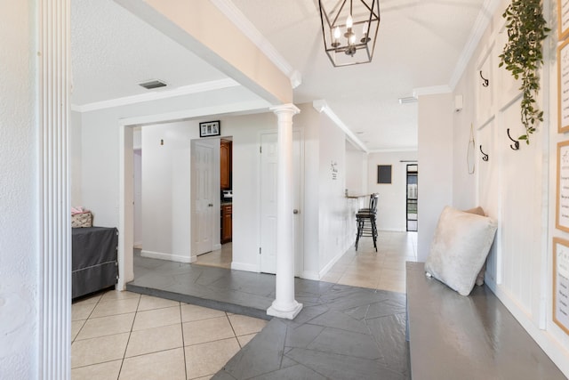 hallway with light tile patterned floors, ornamental molding, decorative columns, and a textured ceiling