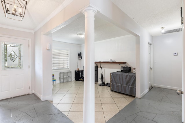 foyer featuring crown molding, decorative columns, and a textured ceiling