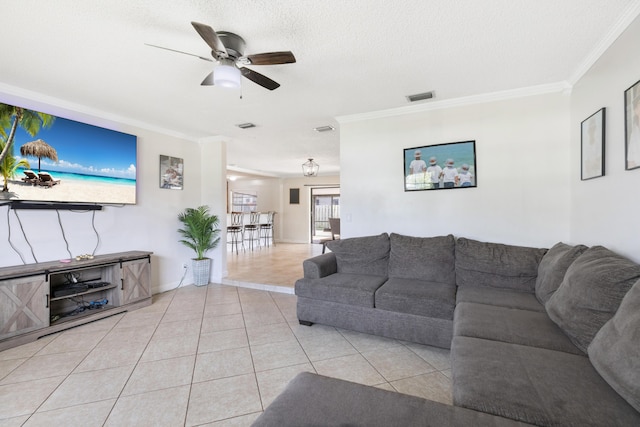 living room with light tile patterned floors, ornamental molding, a ceiling fan, visible vents, and baseboards