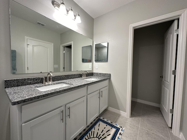 bathroom featuring vanity, tile patterned floors, and a textured ceiling