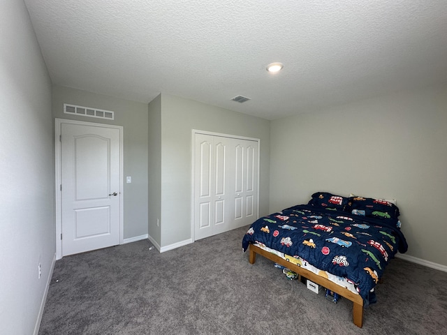 carpeted bedroom featuring a textured ceiling and a closet