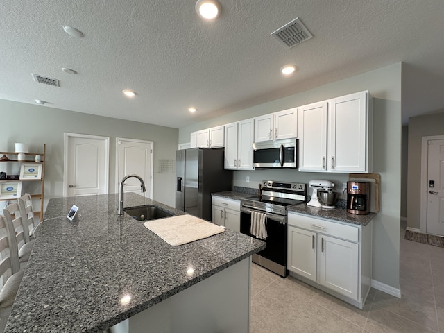 kitchen featuring white cabinetry, stainless steel appliances, a kitchen island with sink, and sink