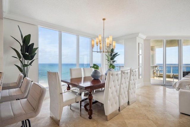 dining space with a textured ceiling, a notable chandelier, a water view, ornamental molding, and expansive windows