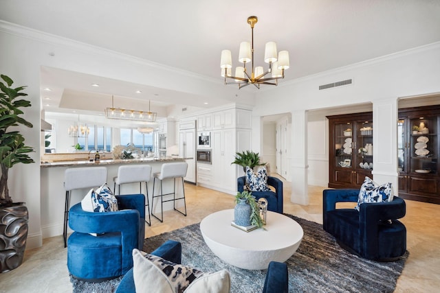 living room with crown molding, decorative columns, and an inviting chandelier