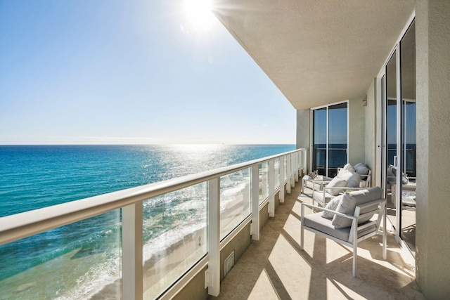 balcony with a water view and a beach view