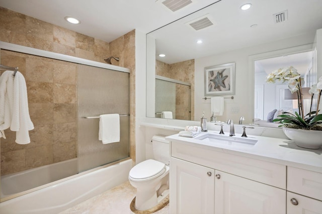 full bath with visible vents, shower / bath combination with glass door, vanity, and toilet