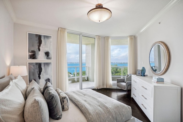 bedroom featuring ornamental molding, dark wood-type flooring, a water view, and access to exterior