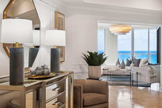 living room featuring a water view, an inviting chandelier, and crown molding