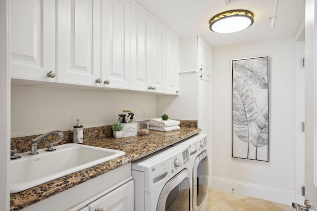 washroom featuring cabinet space, light tile patterned flooring, a sink, independent washer and dryer, and baseboards