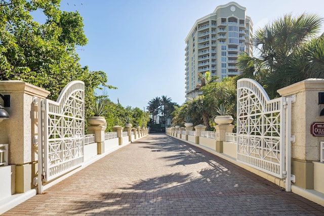 view of road featuring curbs and a gate