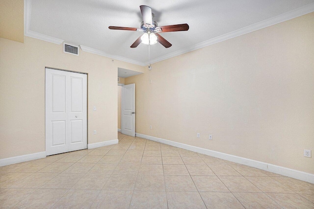 unfurnished bedroom with ornamental molding, light tile patterned flooring, ceiling fan, and a closet