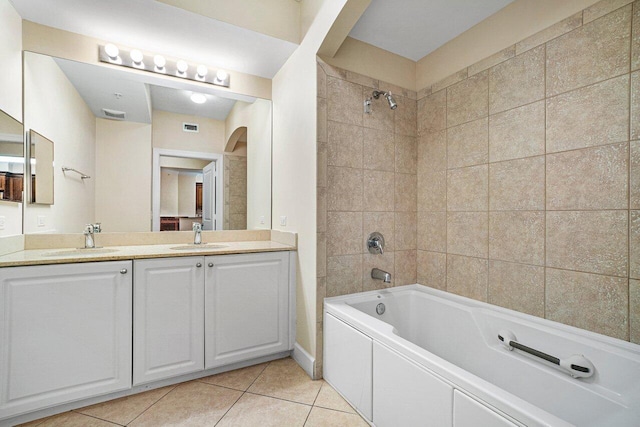 bathroom with tile patterned flooring, tiled shower / bath, and vanity