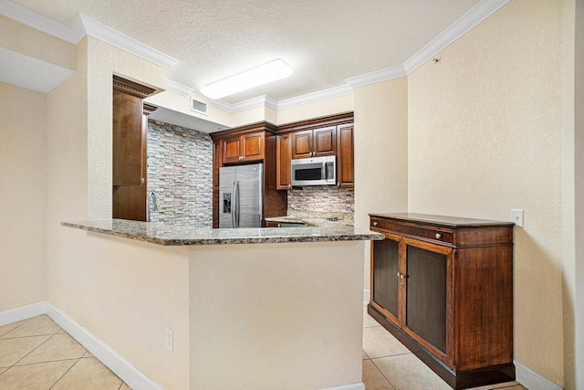 kitchen with light stone countertops, stainless steel appliances, kitchen peninsula, and light tile patterned flooring