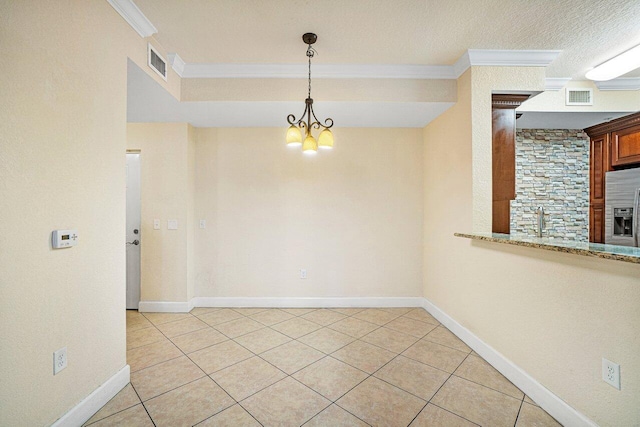 tiled empty room with ornamental molding, a textured ceiling, and a chandelier