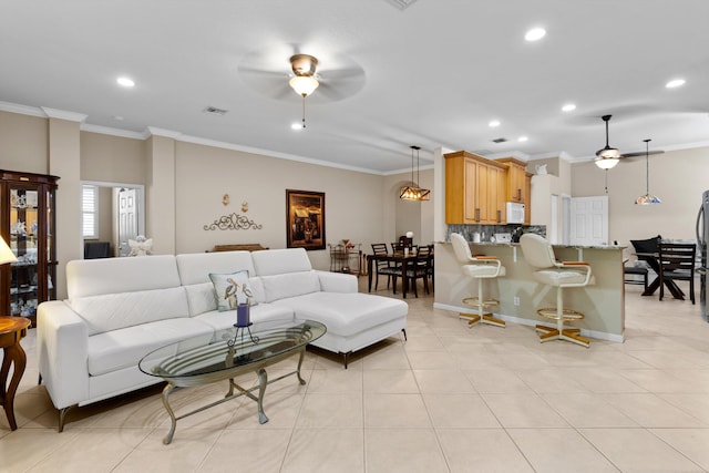 tiled living room with crown molding and ceiling fan