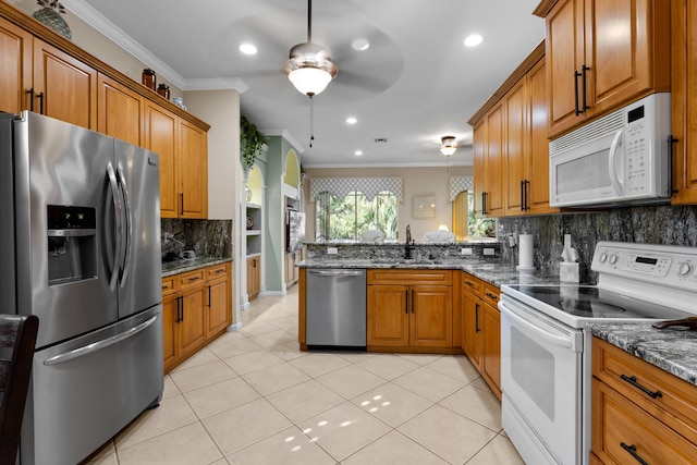 kitchen featuring dark stone countertops, backsplash, ornamental molding, kitchen peninsula, and stainless steel appliances