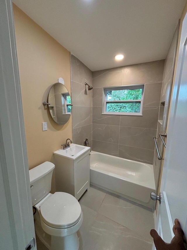 full bathroom with vanity, tiled shower / bath combo, and toilet