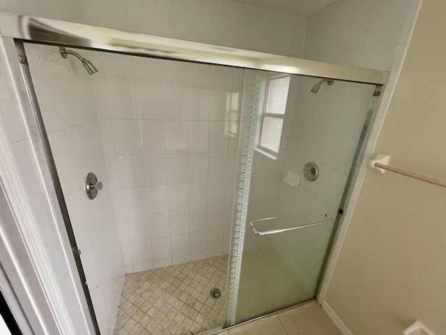 bathroom featuring tile patterned floors and a shower with shower door