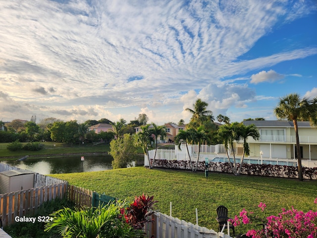 view of yard featuring a fenced in pool and a water view