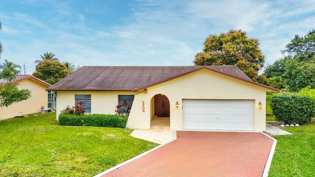 single story home with a garage and a front lawn