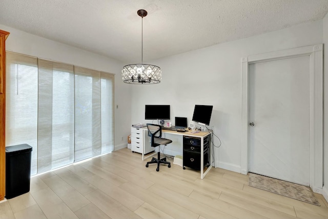 office area with light wood-type flooring and a textured ceiling