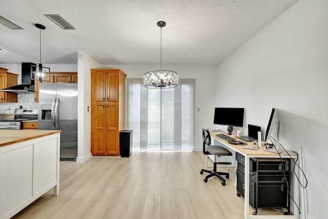 office with a textured ceiling and light wood-type flooring