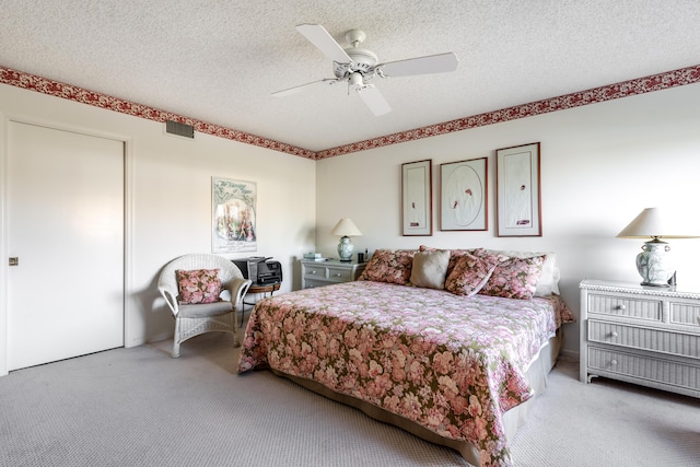 carpeted bedroom with a textured ceiling and ceiling fan