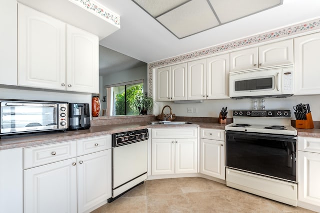 kitchen featuring sink, white appliances, white cabinets, and light tile patterned flooring