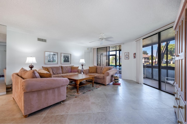 living room with floor to ceiling windows, ceiling fan, and a textured ceiling