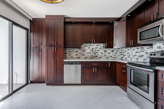 kitchen with stainless steel appliances, tasteful backsplash, sink, and light tile patterned floors