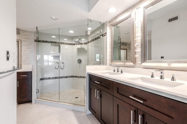 bathroom featuring vanity, a shower with shower door, tile patterned flooring, and tile walls