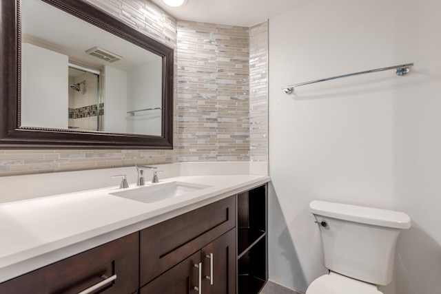 bathroom with vanity, backsplash, and toilet