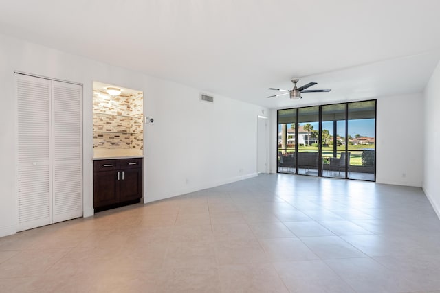 spare room with ceiling fan and floor to ceiling windows