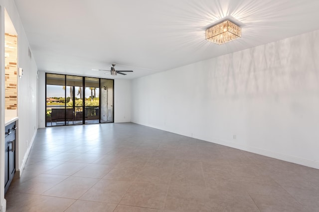 empty room featuring expansive windows and ceiling fan