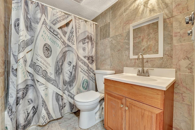 bathroom featuring tile walls, vanity, toilet, a textured ceiling, and a shower with curtain