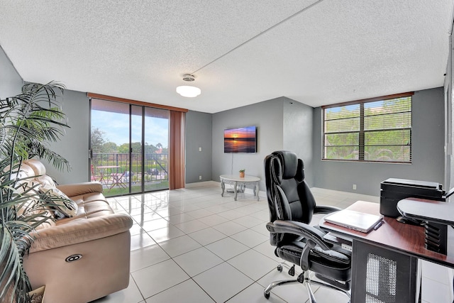 tiled office space featuring a textured ceiling and a healthy amount of sunlight