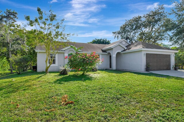 single story home with a garage and a front lawn