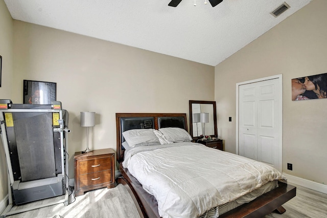 bedroom featuring baseboards, visible vents, ceiling fan, vaulted ceiling, and light wood-type flooring