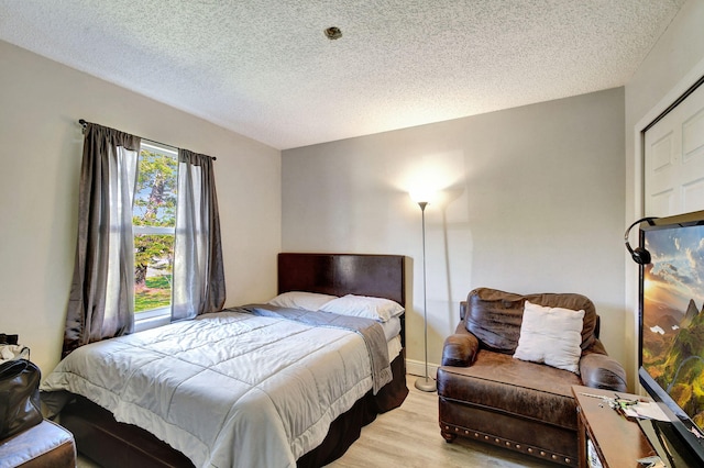 bedroom with light wood-style flooring and a textured ceiling